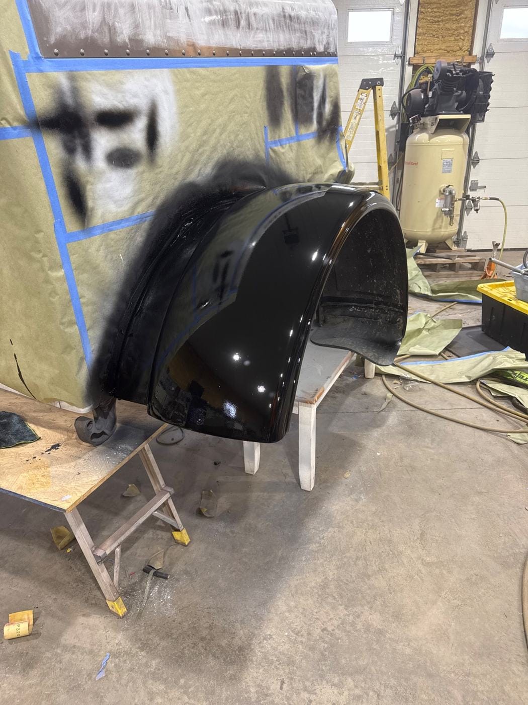A black fender masked off in the paint area.