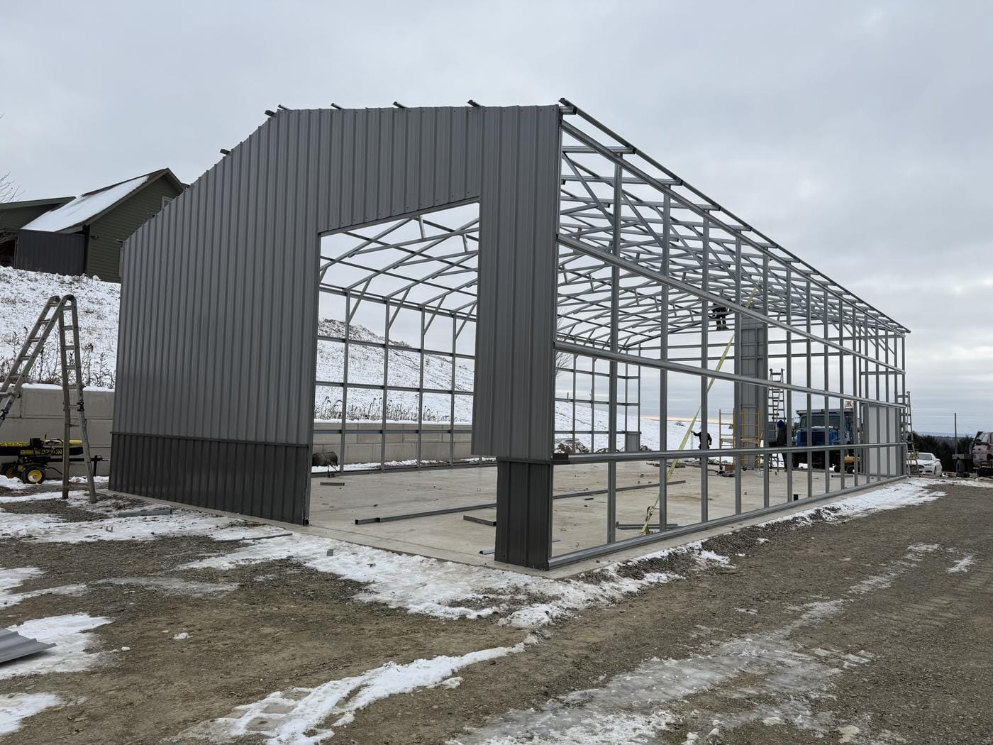 Steel siding going onto the frame, on the slab in the snow.